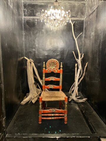 狭い部屋に立派な椅子とシャンデリア